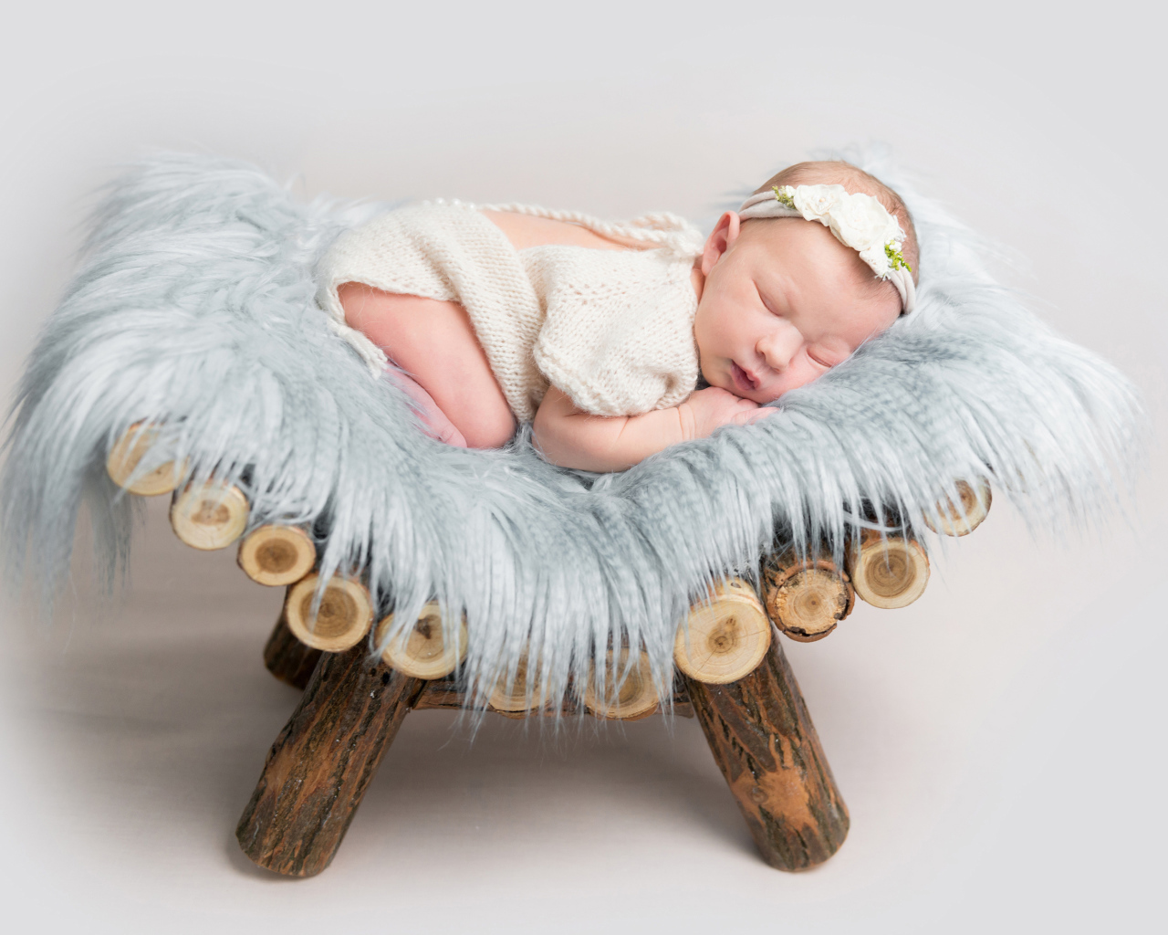 Грудной спящий ребенок лежит на деревянной кроватке