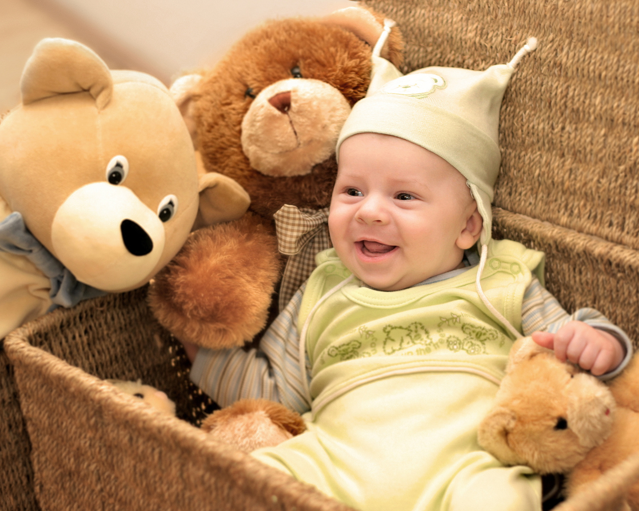 Грудной улыбающийся ребенок в корзине с игрушками