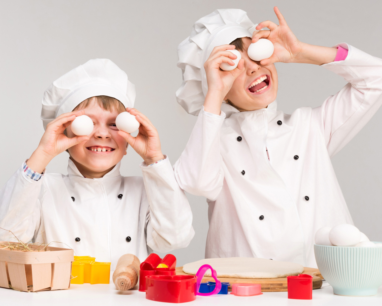 Два маленьких мальчиках в костюмах повара на кухне