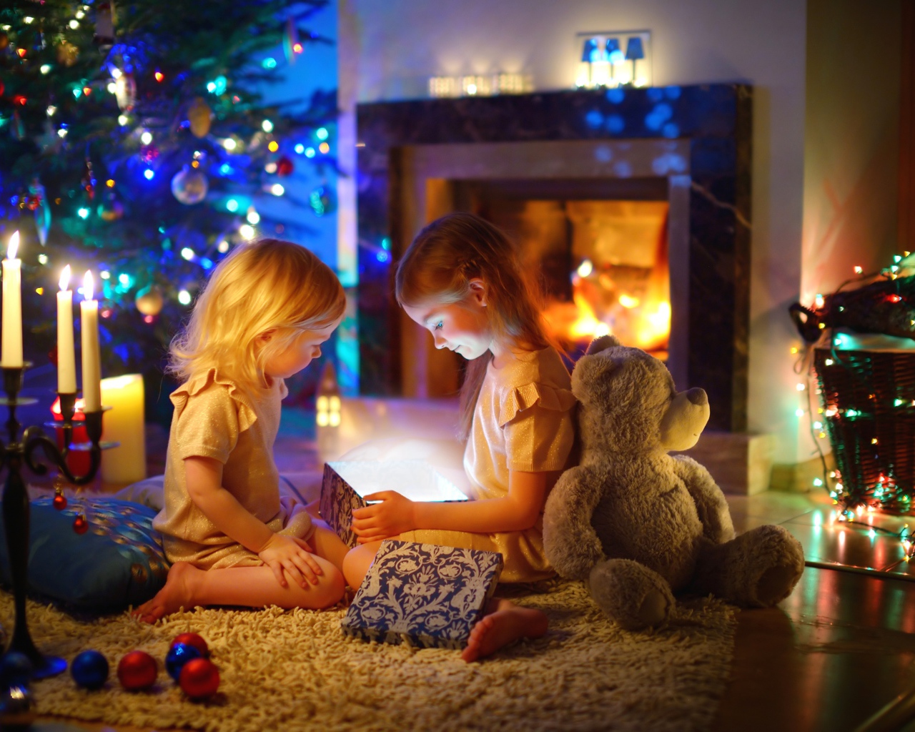 Две маленькие девочки с игрушками у камина