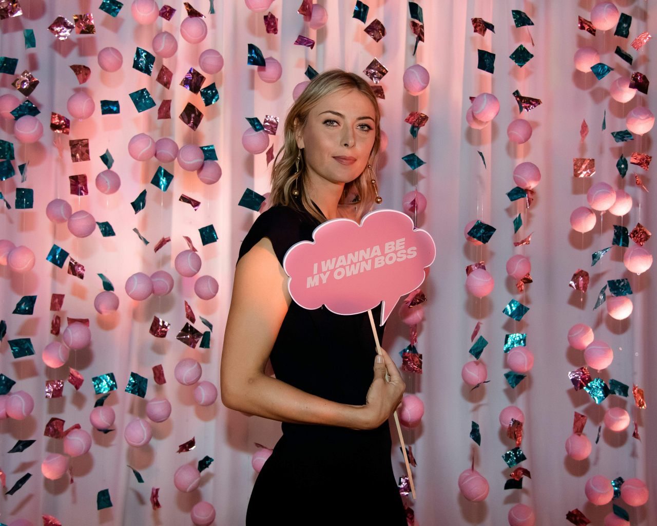 Теннисистка Мария Шарапова с табличкой в руках на розовом фоне