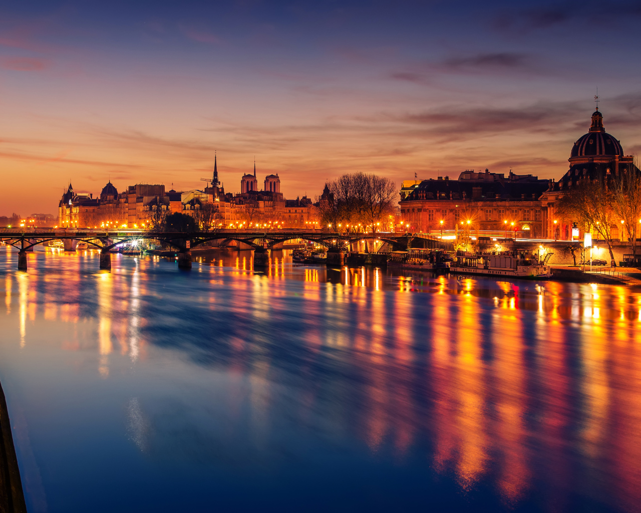 Причал у реки в свете ночных фонарей города Париж, Франция