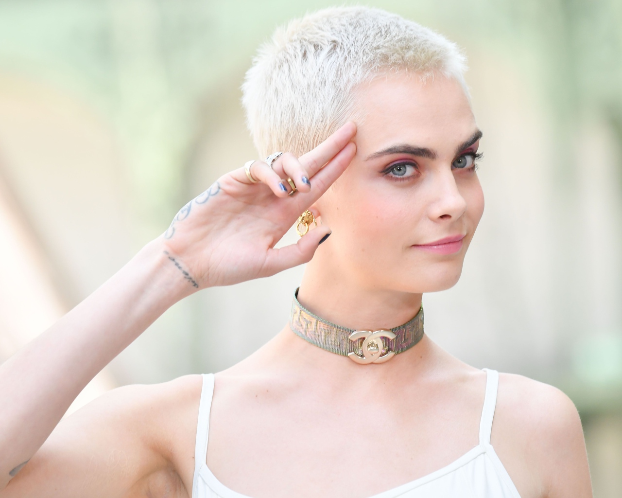 Актриса Кара Делевинь с короткой стрижкой и татуировкой на руке