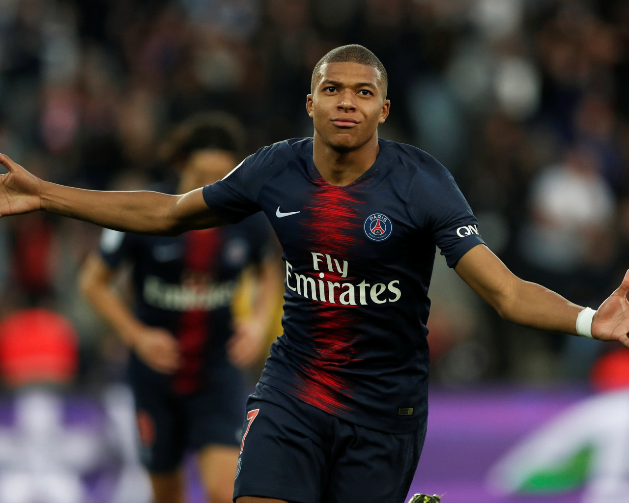 Французский футболист Килиан Мбаппе бежит по полю