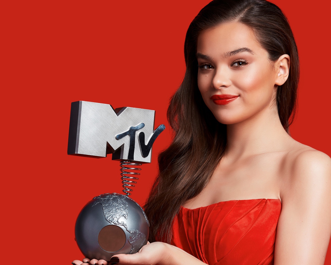 Хейли Стейнфилд с премией MTV на красном фоне