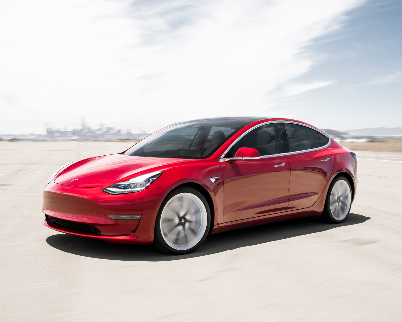 Красный  автомобиль Tesla Model 3, 2018 года под красивым небом