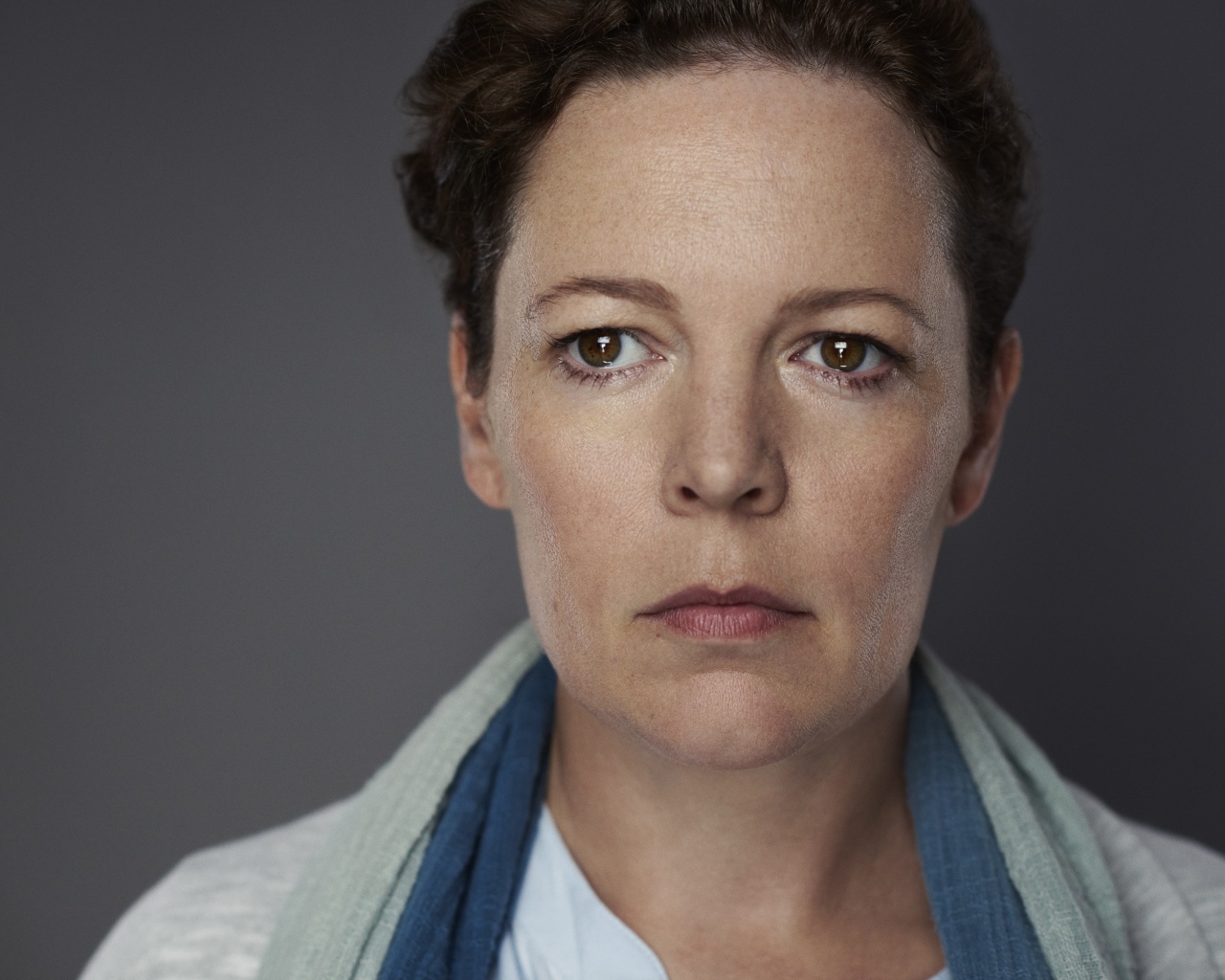 Грустная актриса Оливия Колман на сером фоне