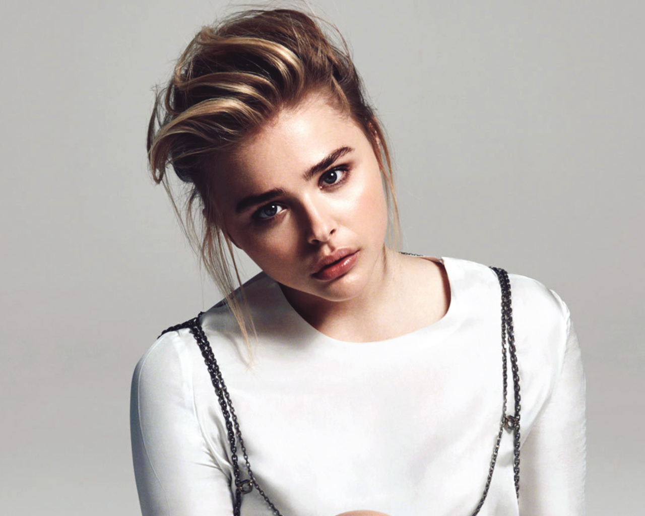 Грустная девушка актриса Хлоя Грейс Морец на сером фоне