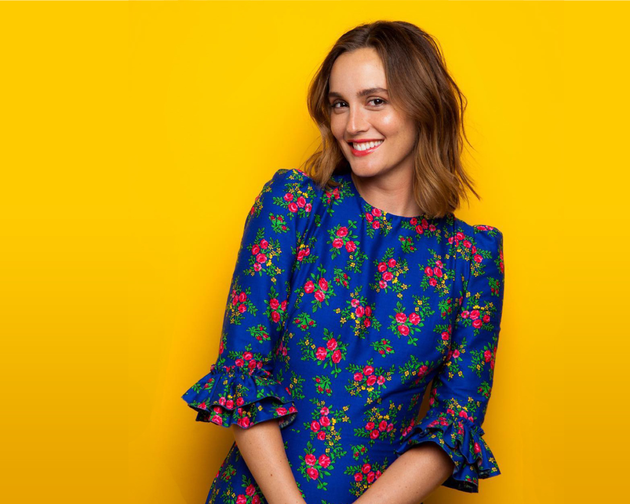 Улыбающаяся актриса Лейтон Мистер в красивом платье на желтом фоне 