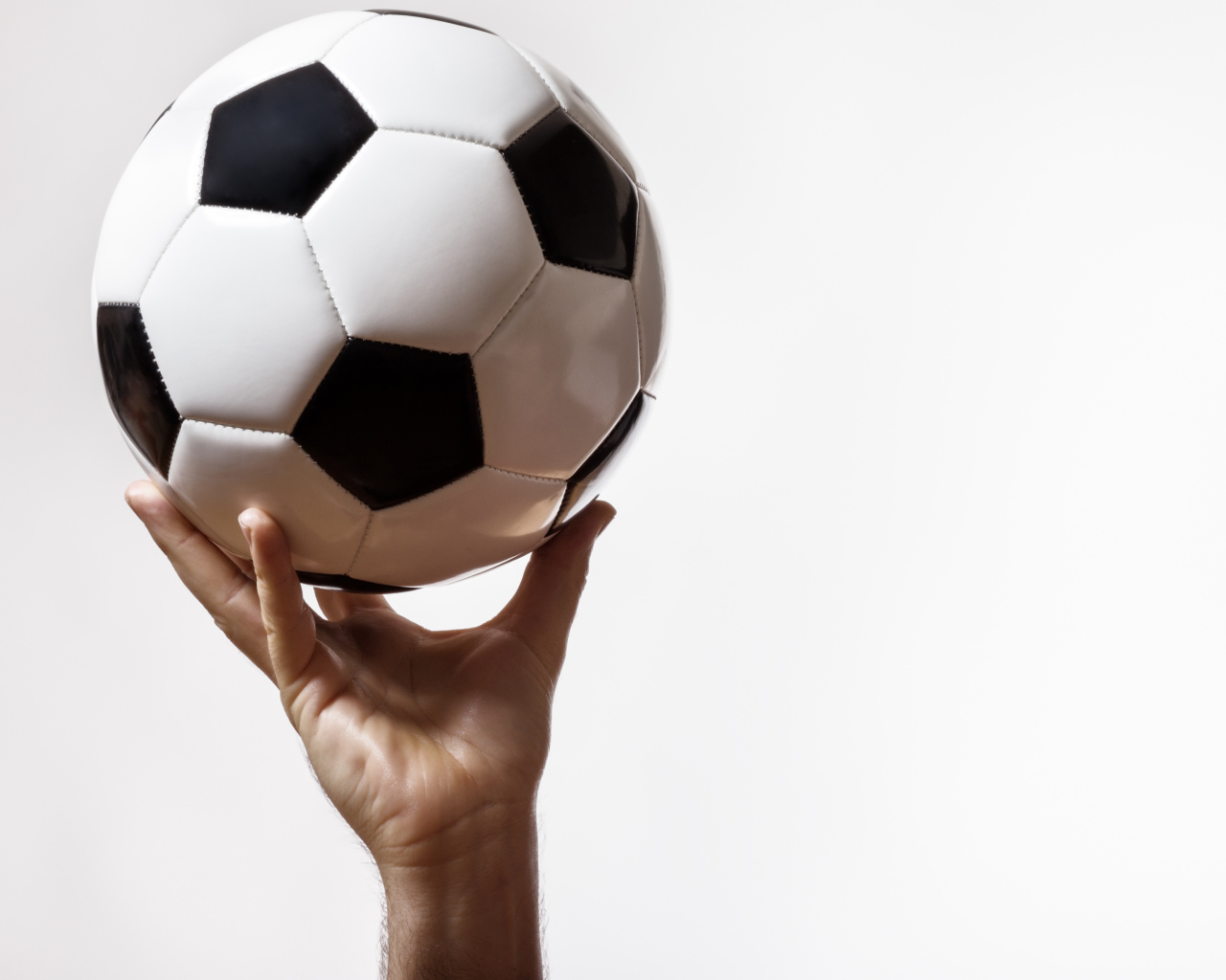 Футбольный мяч в руке на белом фоне
