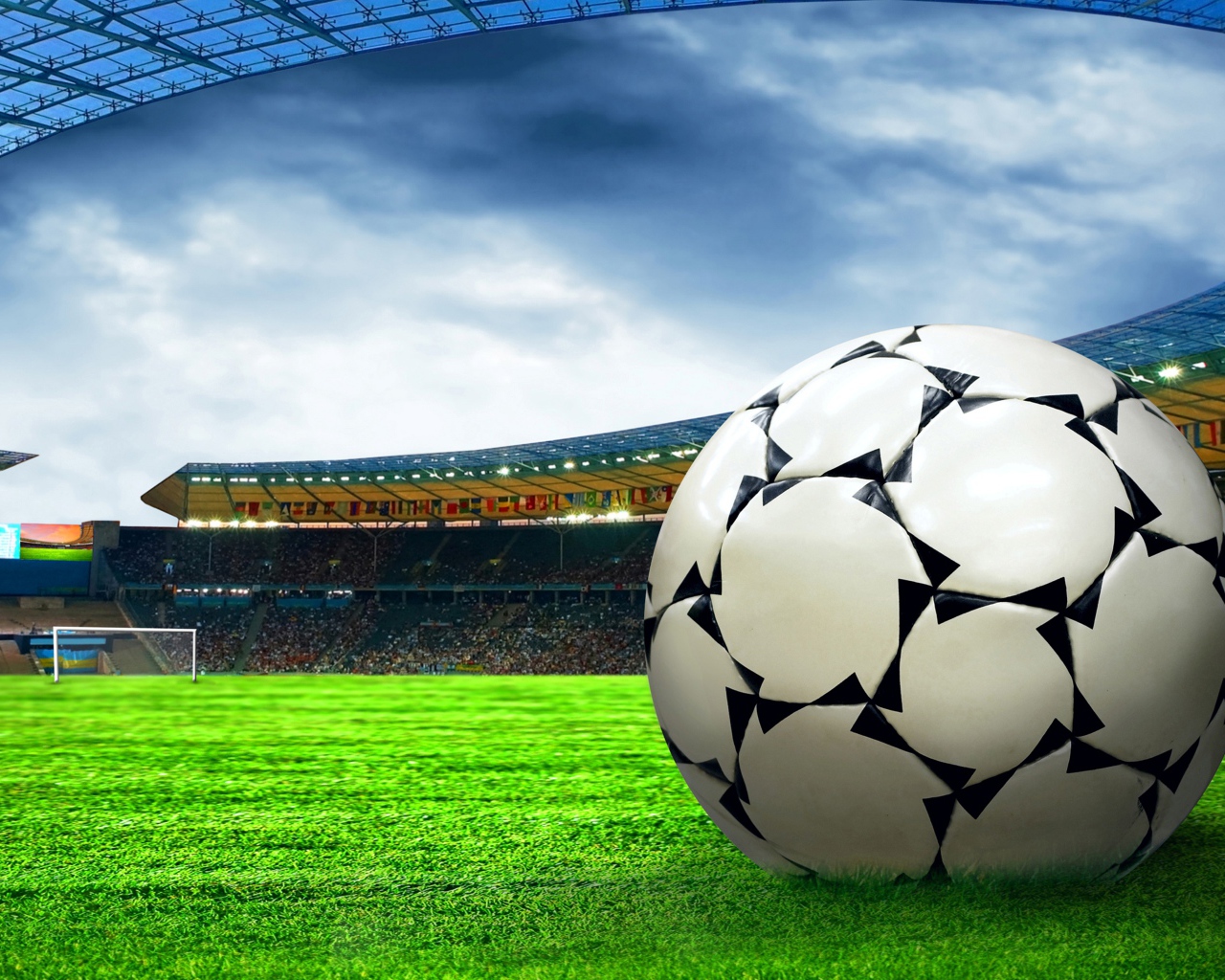 Футбольный мяч на зеленой траве стадиона