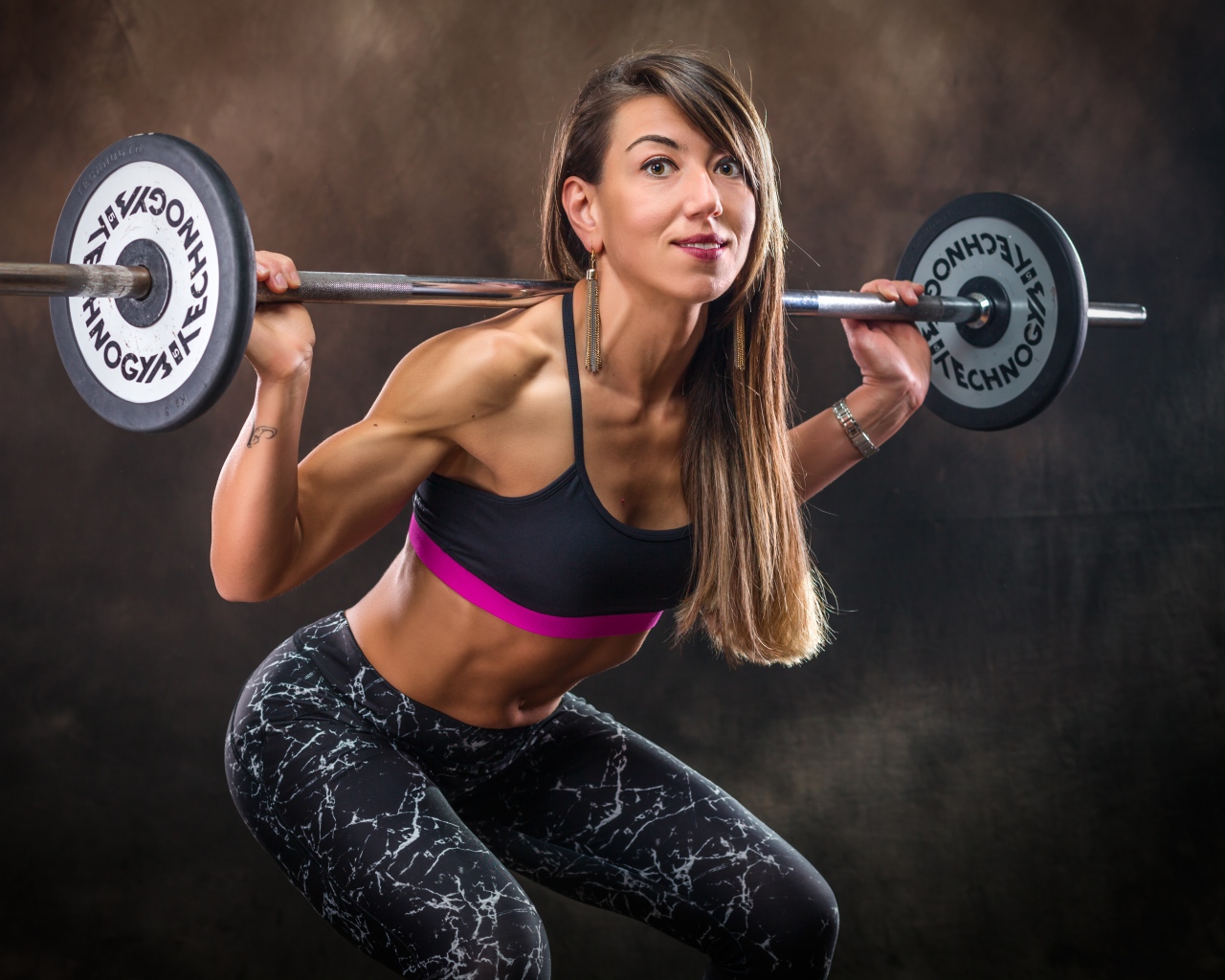 Спортивная накаченная девушка со штангой 