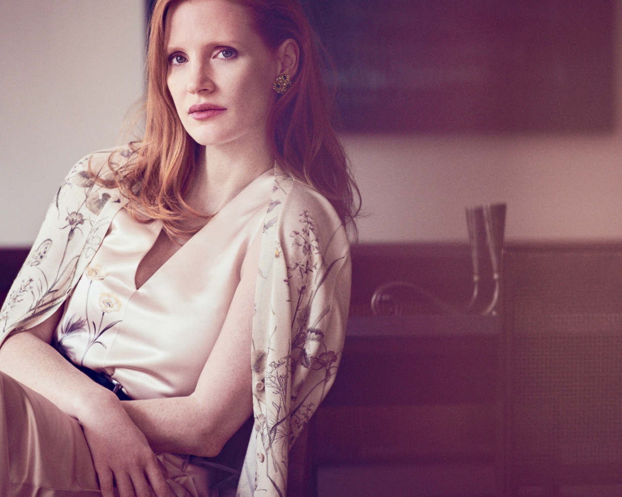 Молодая рыжеволосая актриса Джессика Честейн сидит на стуле