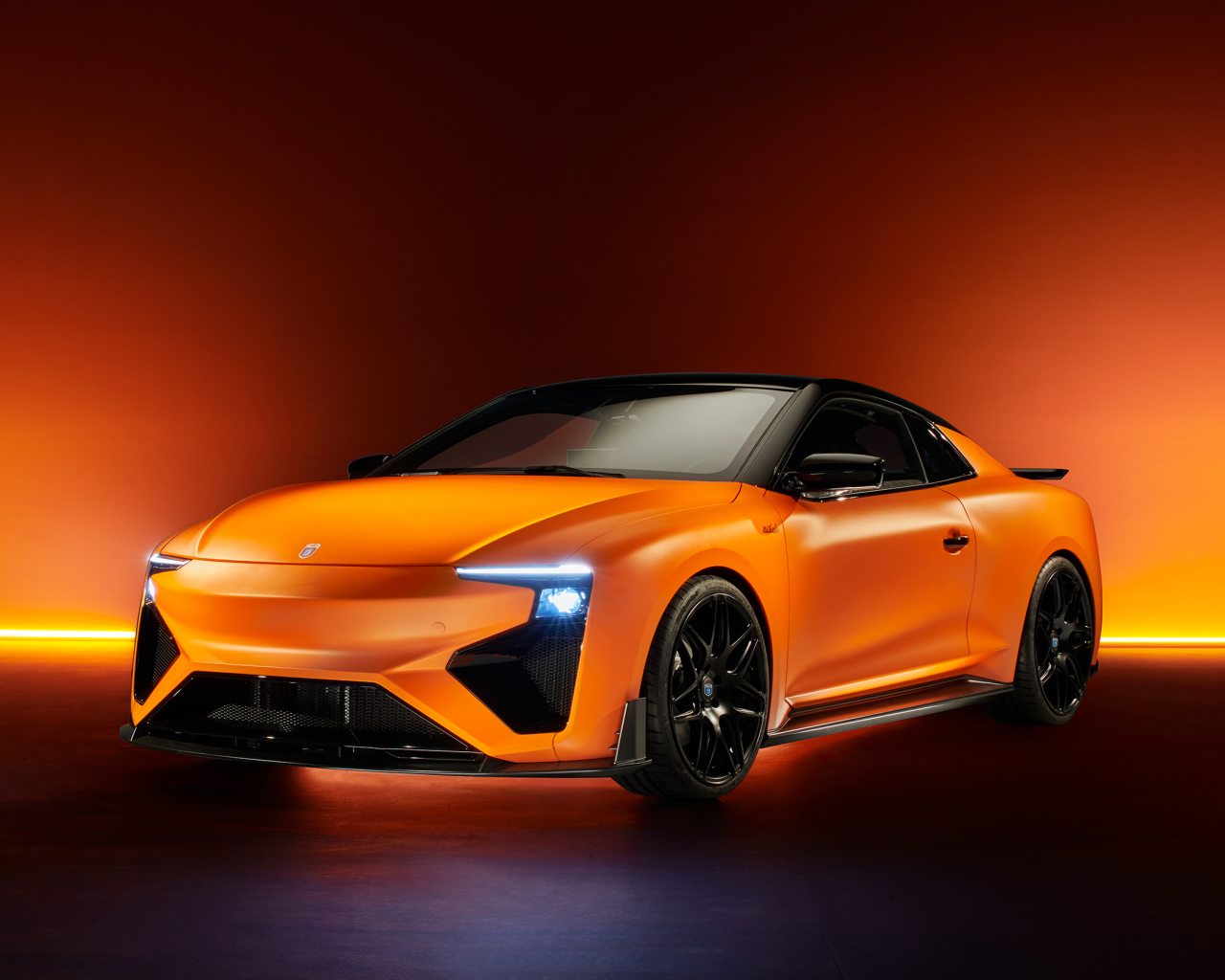 Оранжевый автомобиль Gumpert RG Nathalie 2019 года с включенными фарами