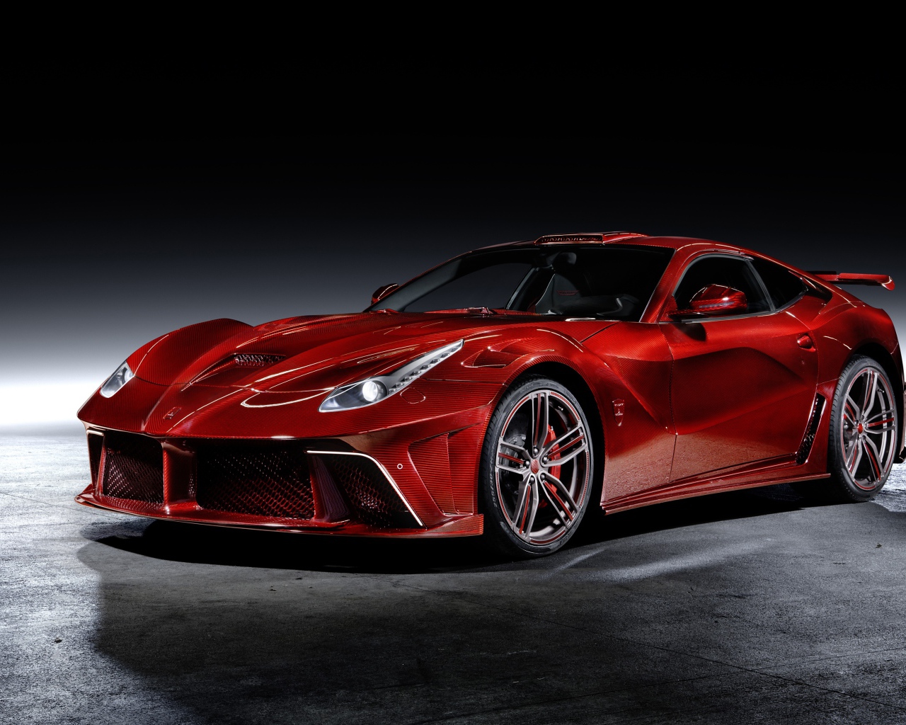 Красный автомобиль Mansory La Revoluzione на сером фоне