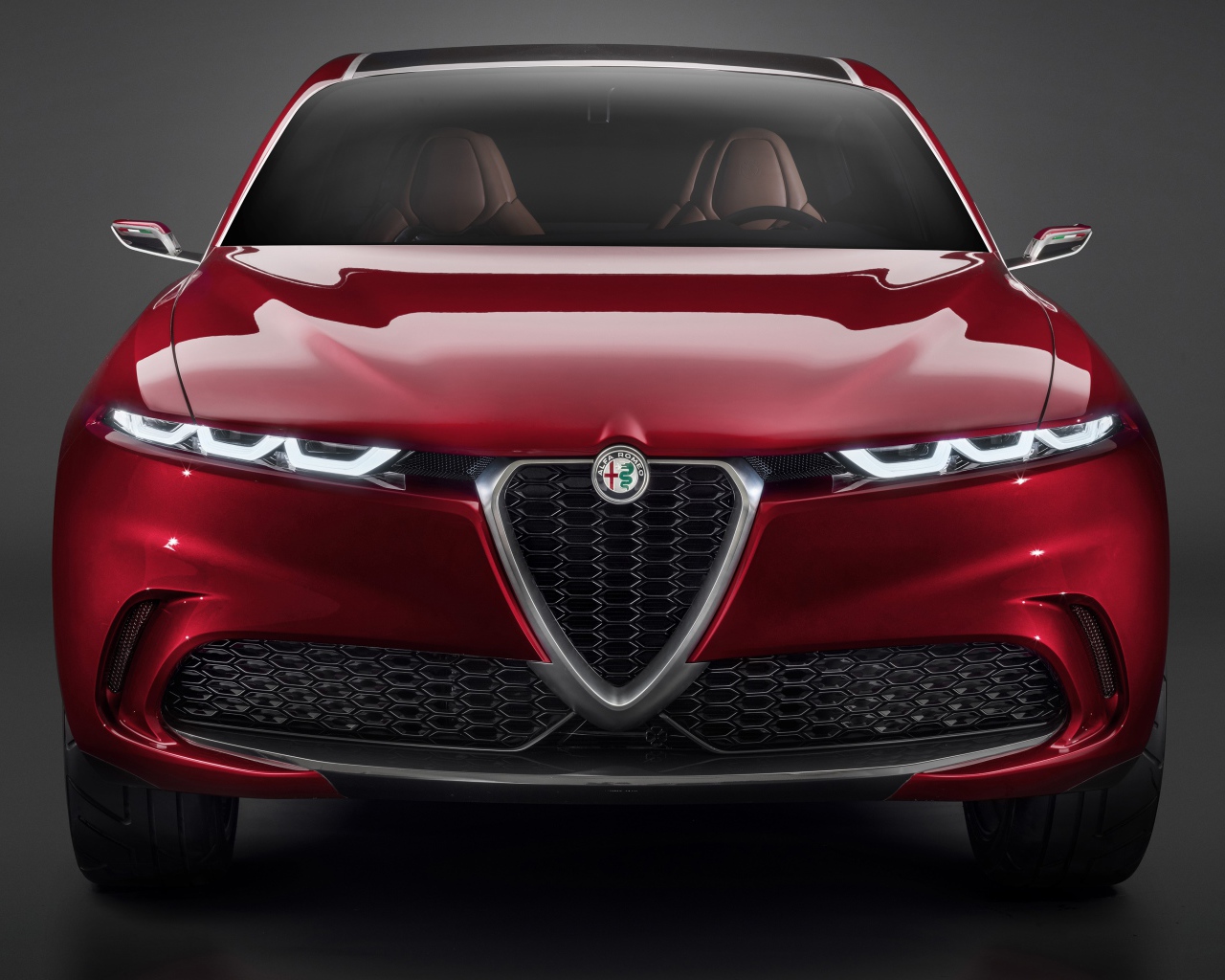 Красный автомобиль Alfa Romeo Tonale Concept,  2019 года вид спереди на сером фоне