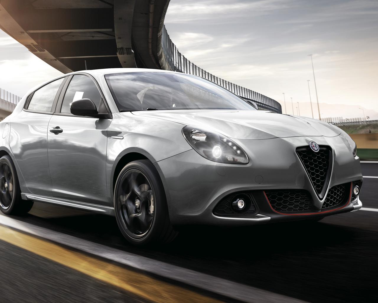 Серебристый автомобиль Alfa Romeo Giulietta Sport 2019 года под мостом