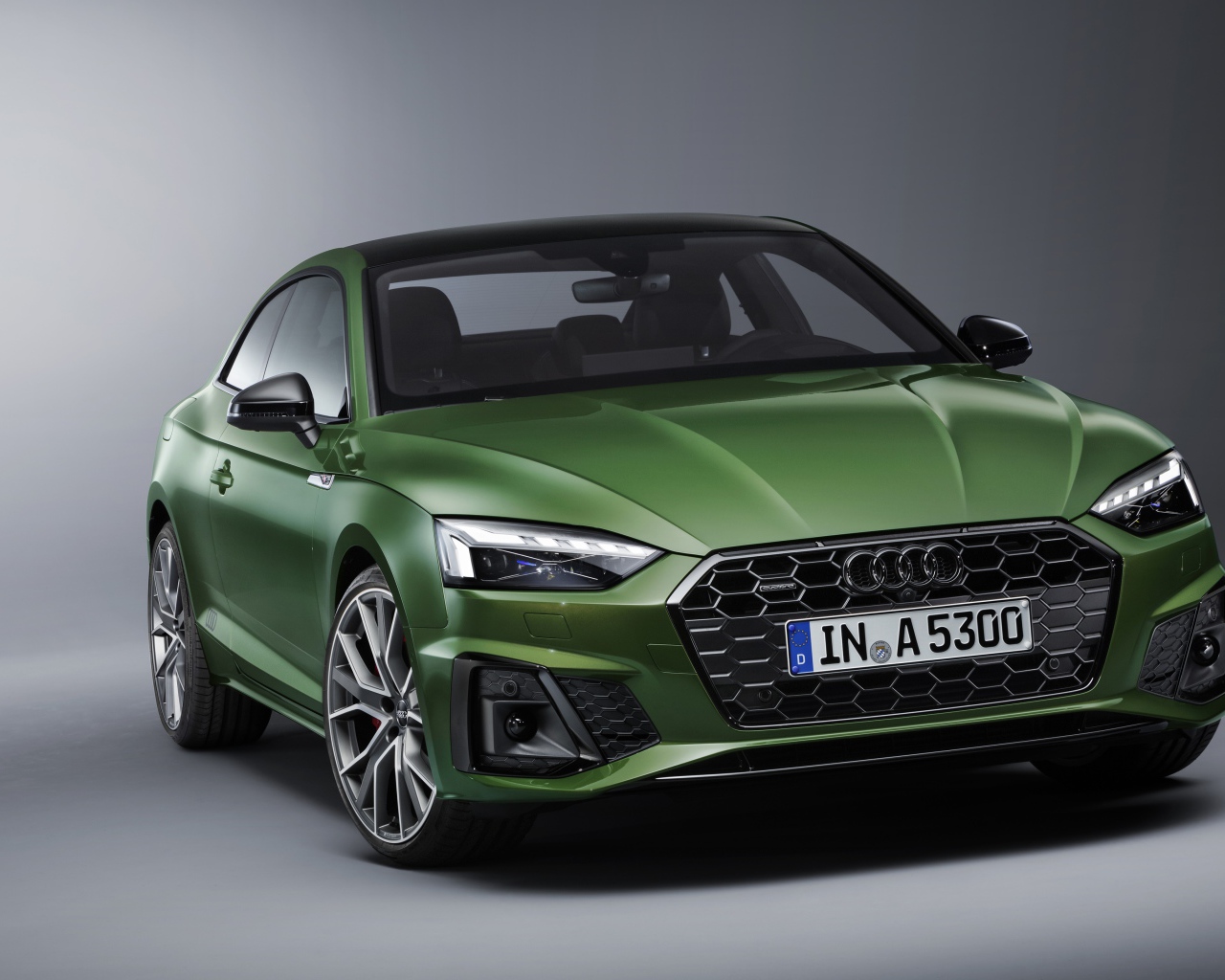 Зеленый автомобиль Audi A5 Coupe 40 TFSI Quattro S Line 2019 года на сером фоне