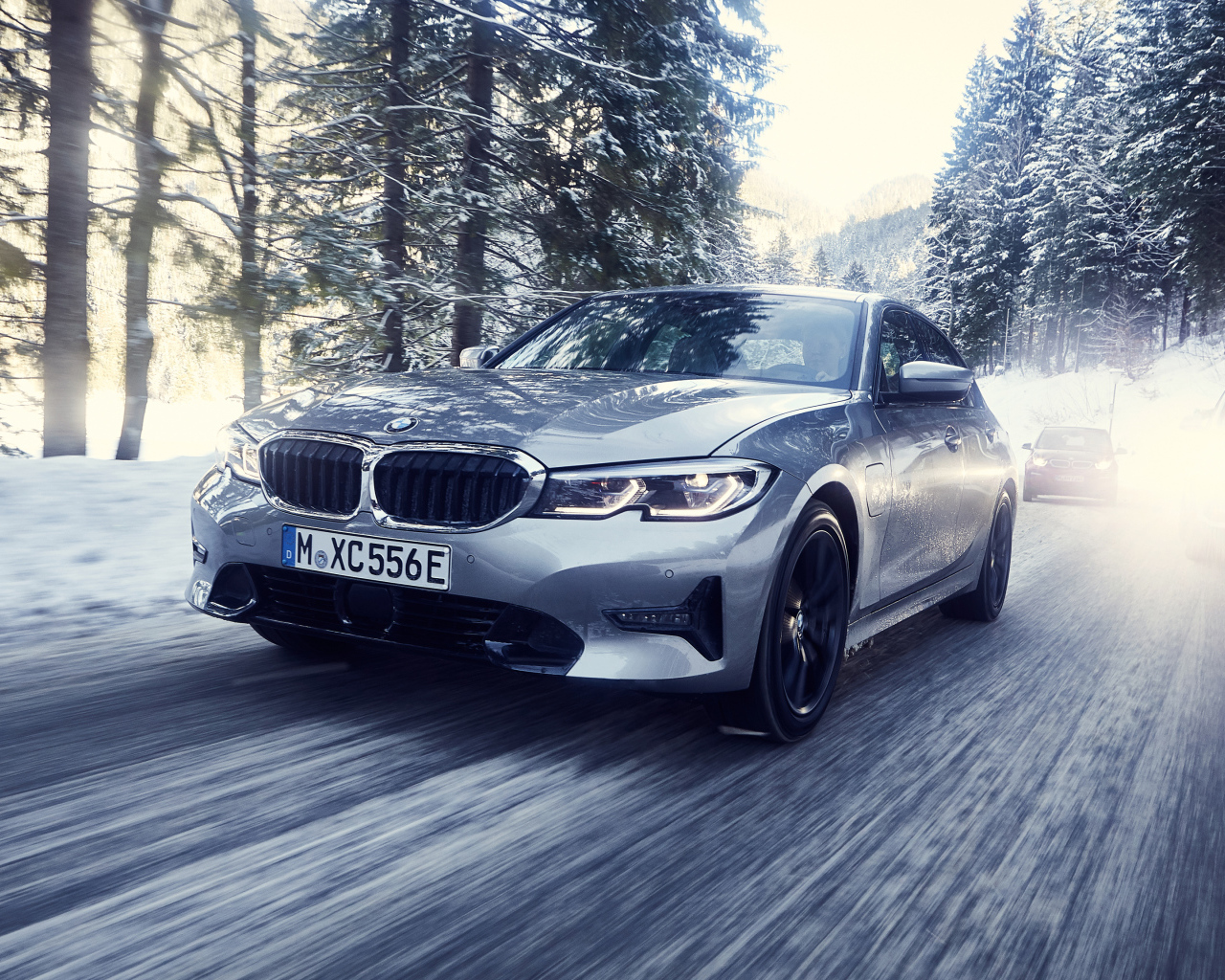 Серый автомобиль BMW 330e 2019 года на скользкой трассе