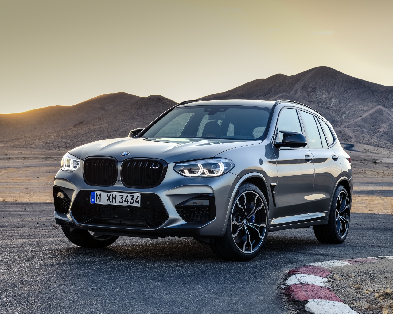 Серебристый автомобиль BMW X3  на асфальте