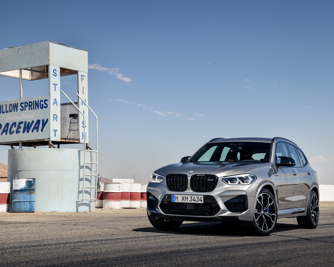 Серебристый автомобиль BMW X3 на асфальте