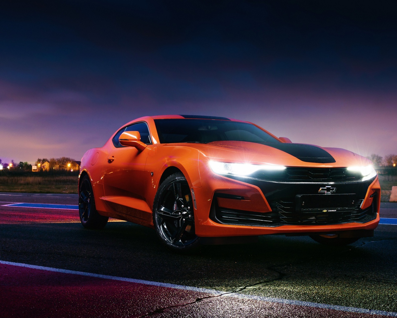 Оранжевый автомобиль Chevrolet Camaro, 2019 года с включенными фарами