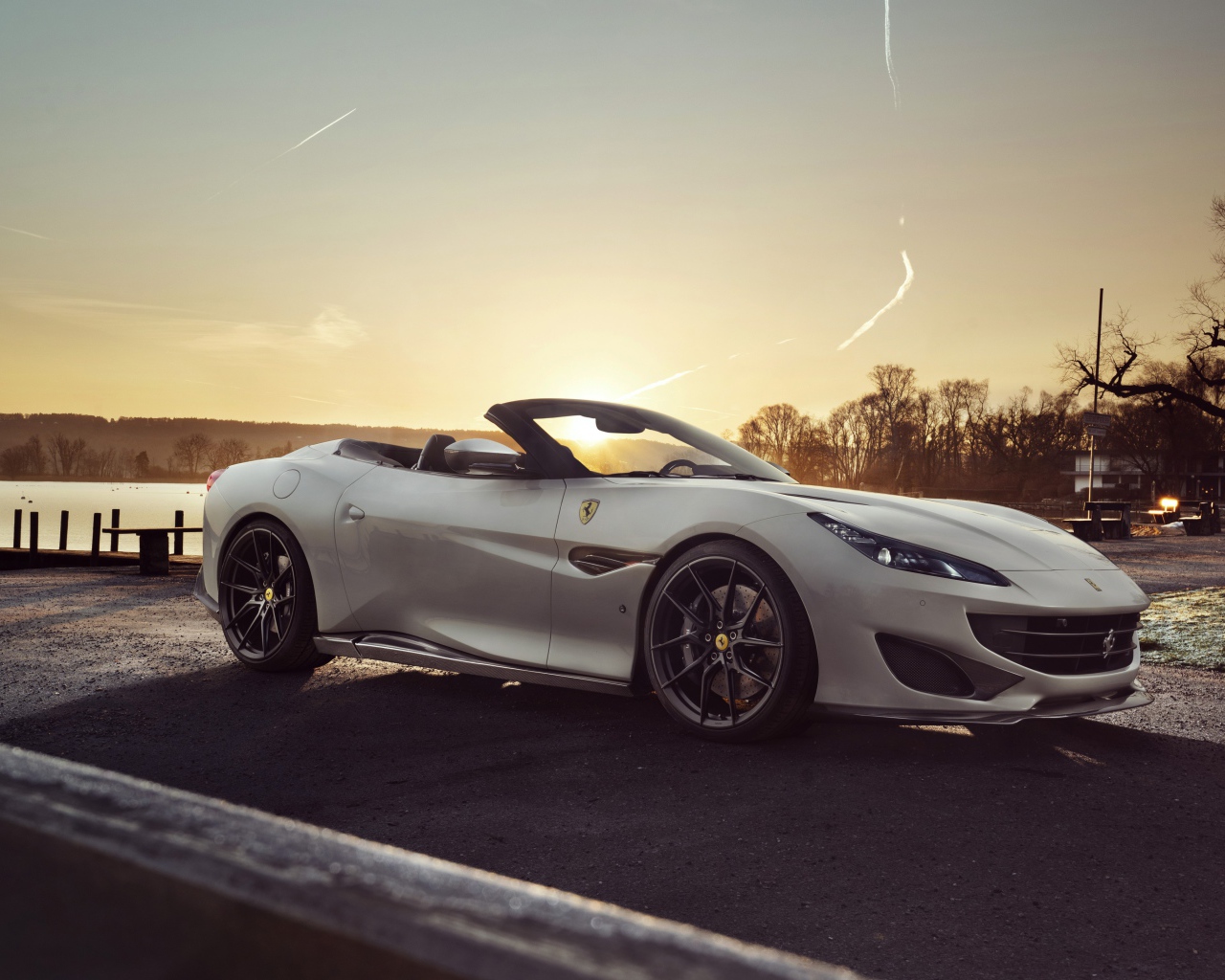 Серебристый кабриолет Ferrari Portofino 2019 года на фоне заката