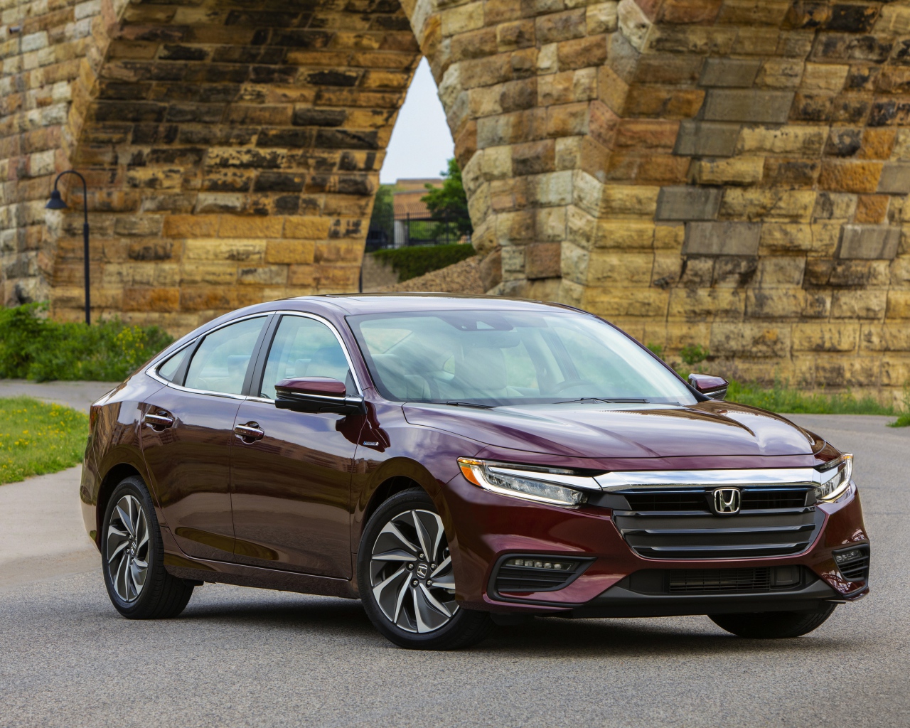 Бордовый автомобиль Honda Insight у моста