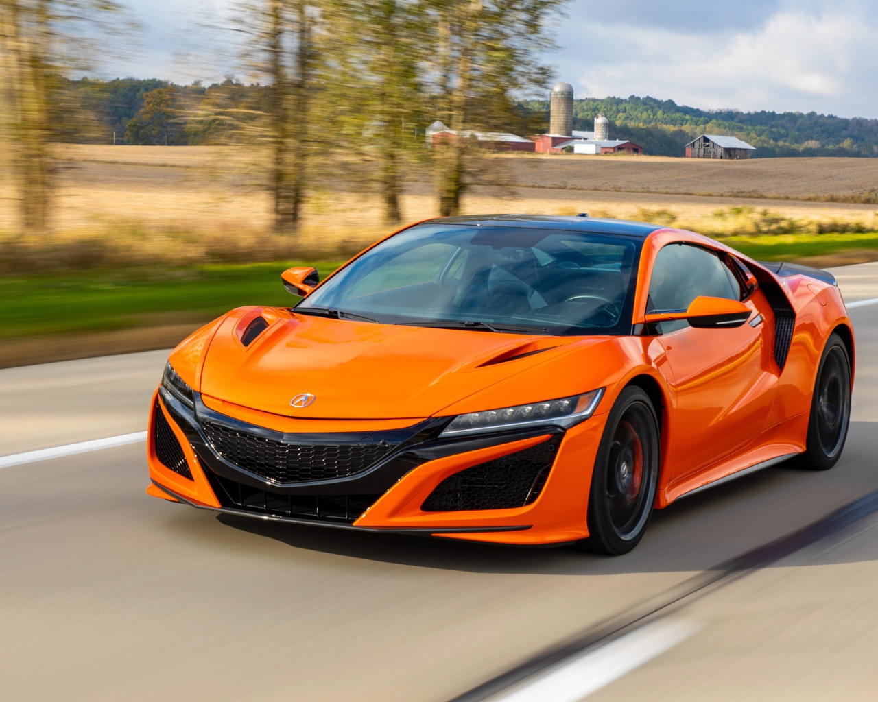 Оранжевый автомобиль Honda NSX на трассе