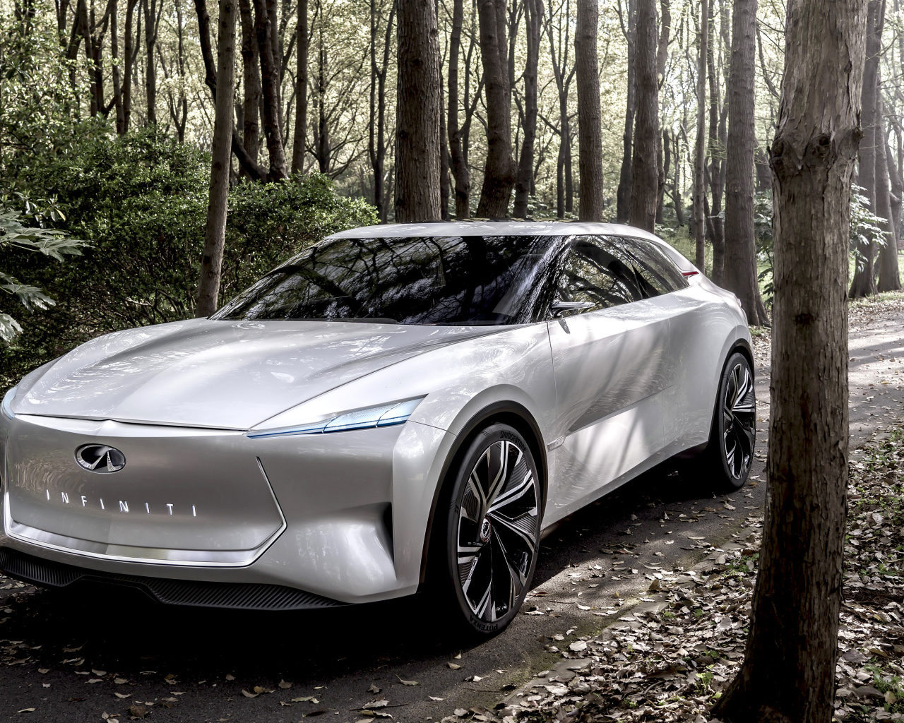 Серебристый автомобиль Infiniti Qs Inspiration 2019 года в лесу