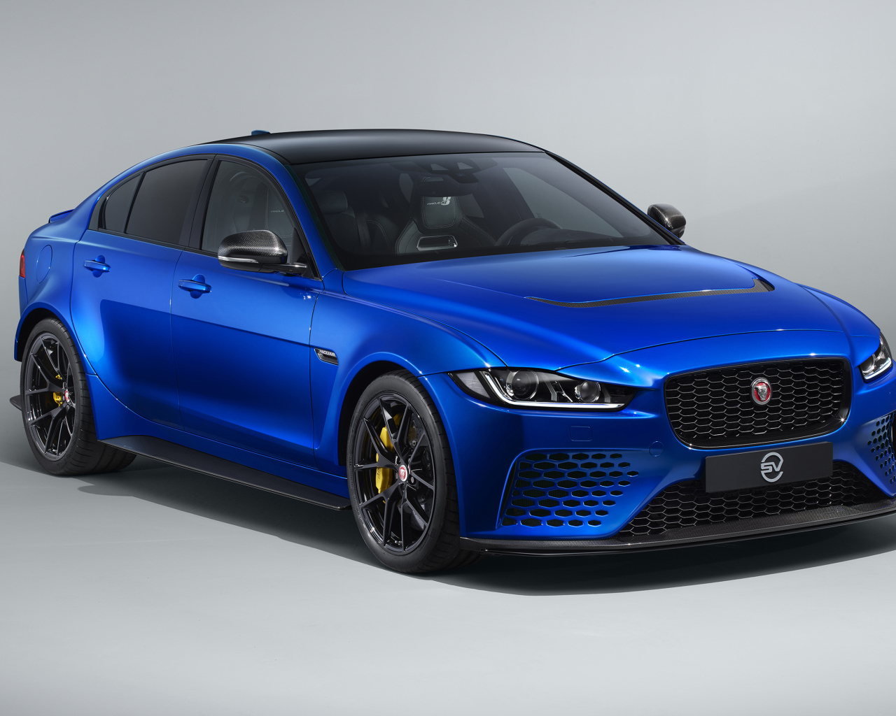 Синий автомобиль Jaguar XE SV Project 8 Touring, 2019 года на сером фоне