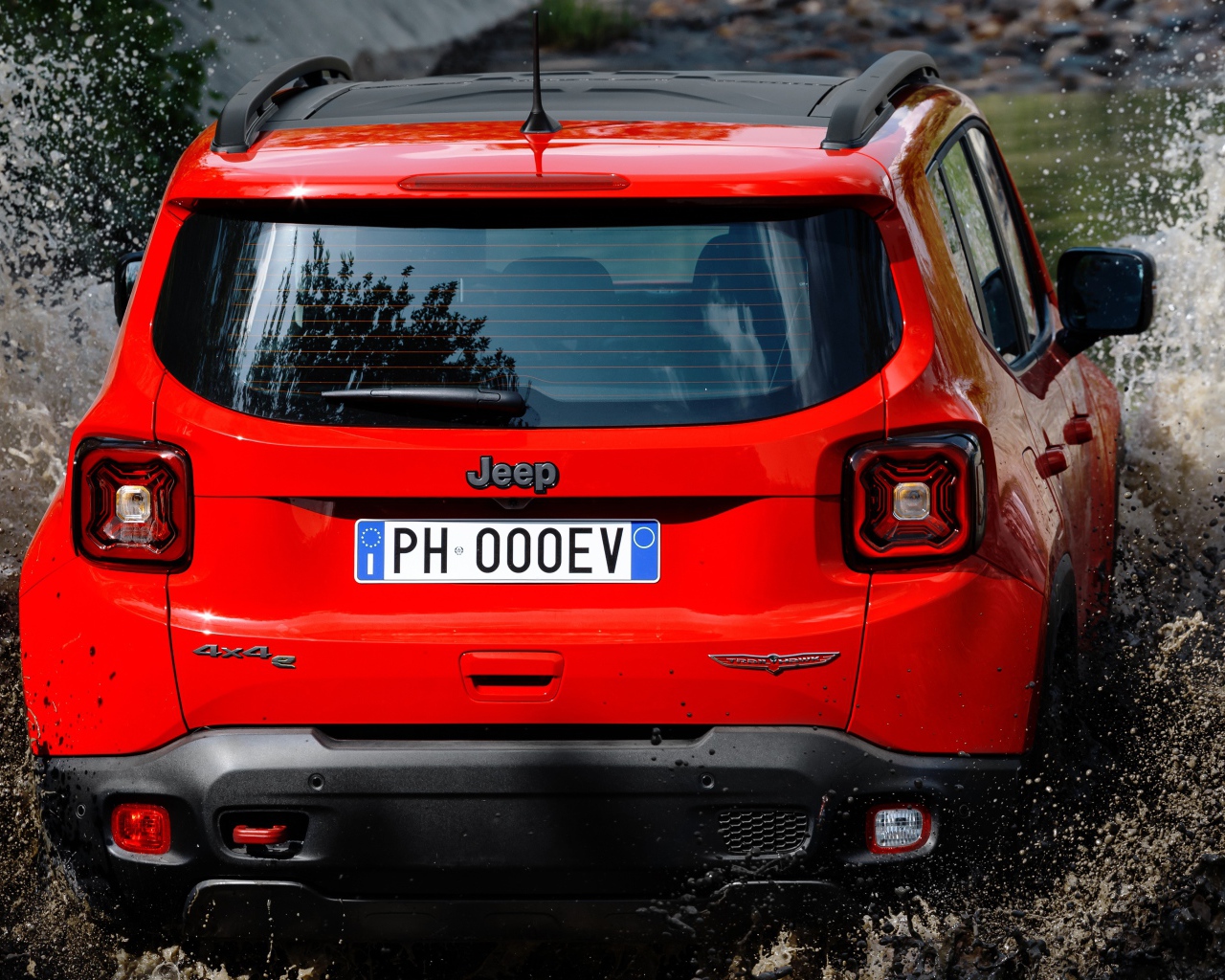 Красный Jeep Renegade Trailhawk Plug-In Hybrid, 2019 года едет по воде вид сзади