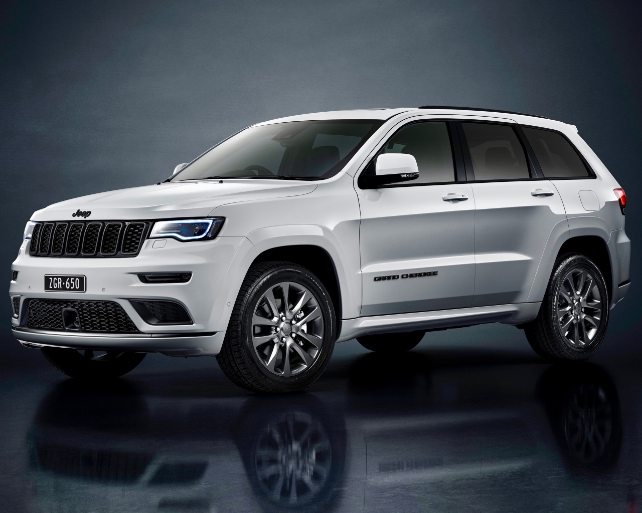 Серый внедорожник Jeep Grand Cherokee S Overland 2019 года на сером фоне