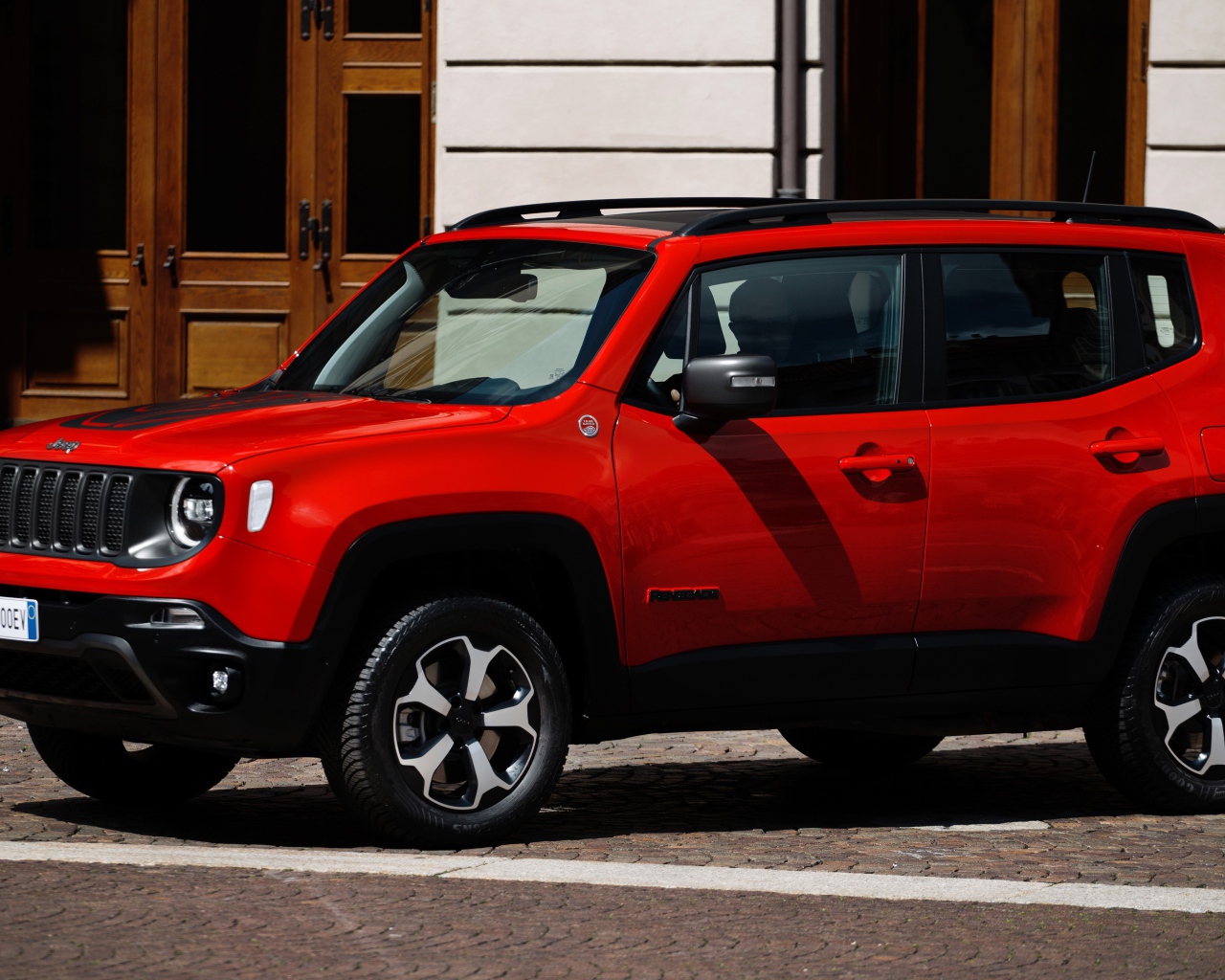 Красный Jeep Renegade Trailhawk Plug-In Hybrid, 2019 года у здания