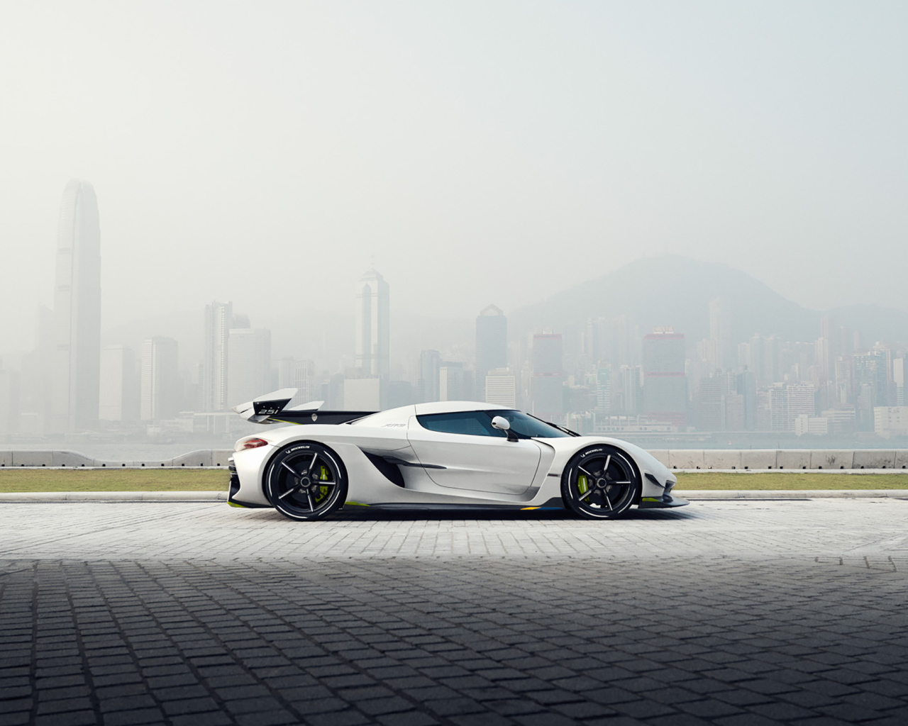 Белый автомобиль  Koenigsegg Jesko, 2019 года на фоне туманного города