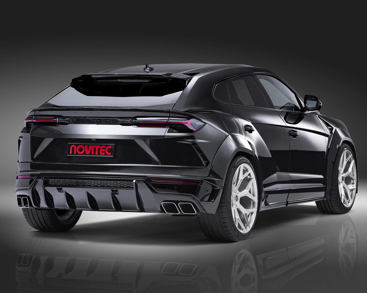 Черный Novitec Lamborghini Urus Esteso 2019 года вид сзади на сером фоне