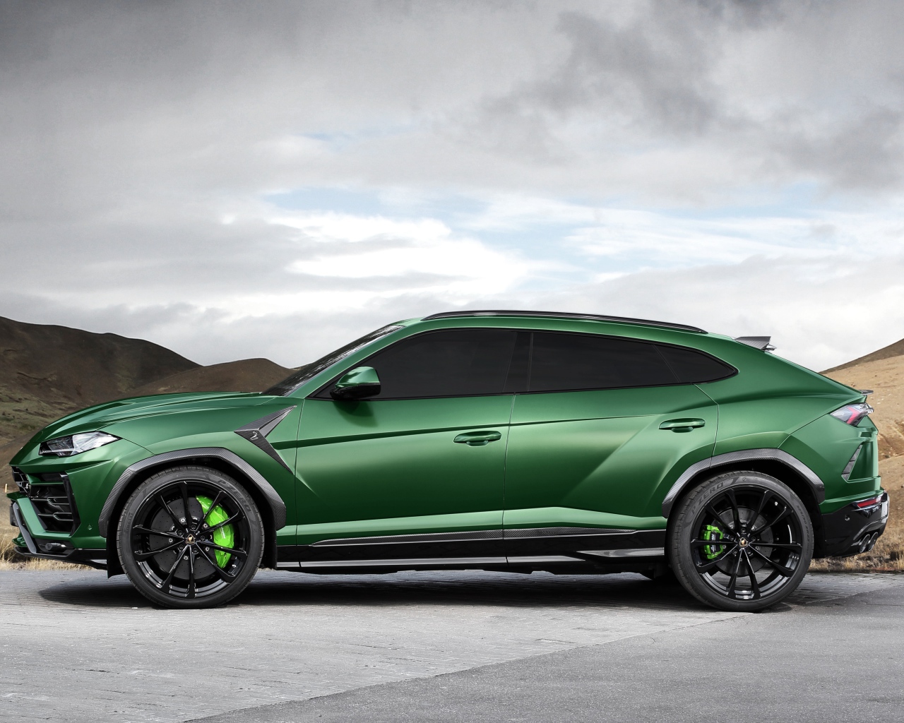 Зеленый автомобиль Lamborghini Urus вид сбоку