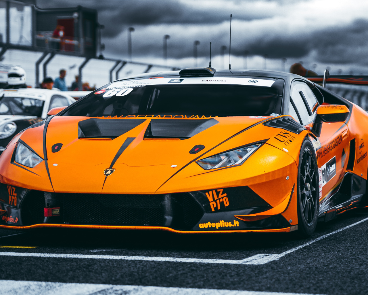 Оранжевый автомобиль Lamborghini Aventador на гонках