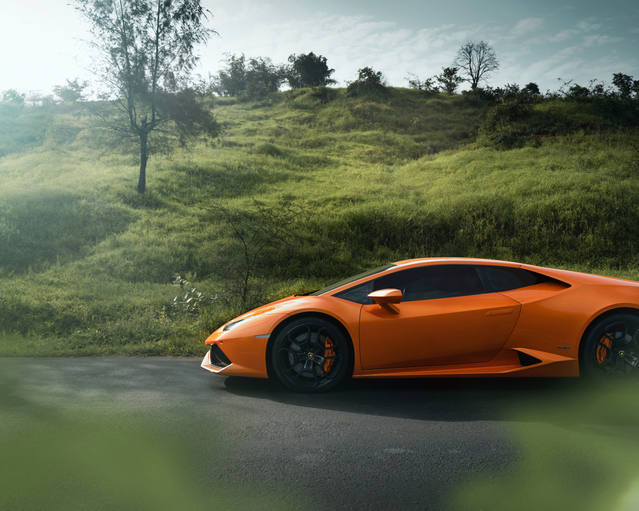 Оранжевый автомобиль Lamborghini Huracan 2019 вид сбоку