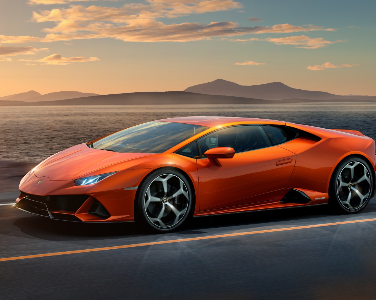Оранжевый автомобиль Lamborghini Huracan EVO 2019 года на фоне неба 