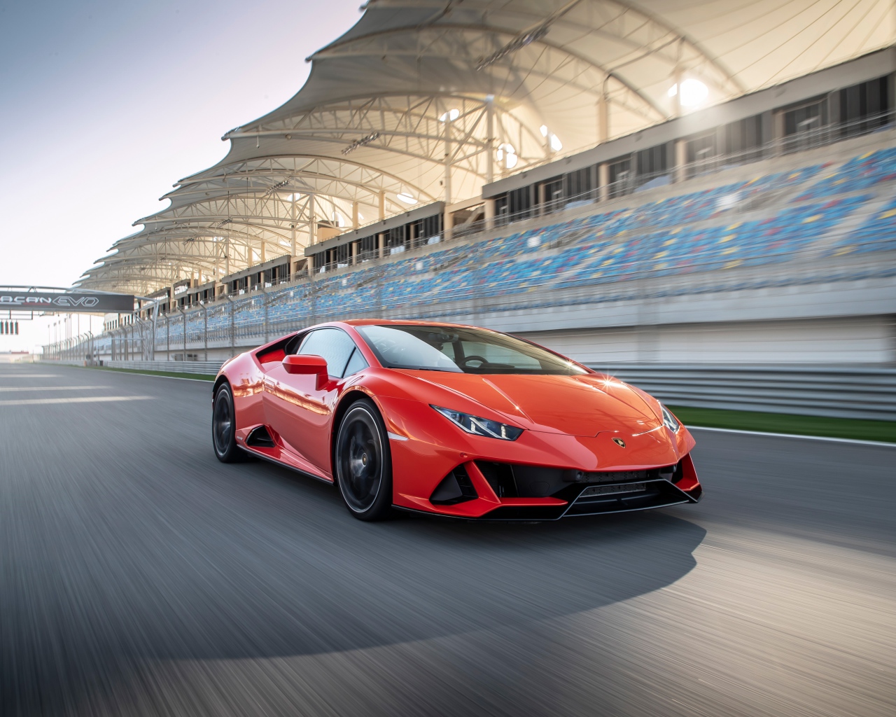 Спортивный красный автомобиль Lamborghini Huracan Evo на гоночной трассе