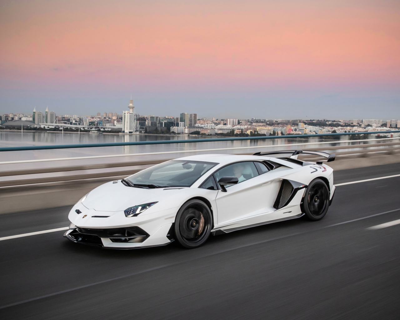 Белый автомобиль Lamborghini Aventador на трассе