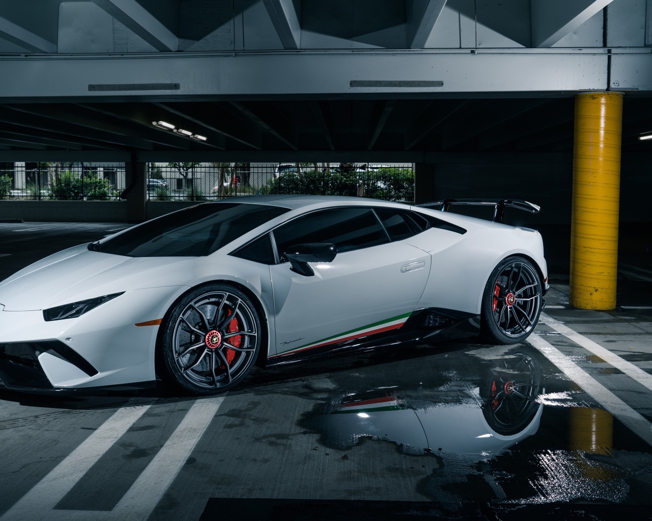 Белый спортивный автомобиль Lamborghini Aventador на подземной парковке