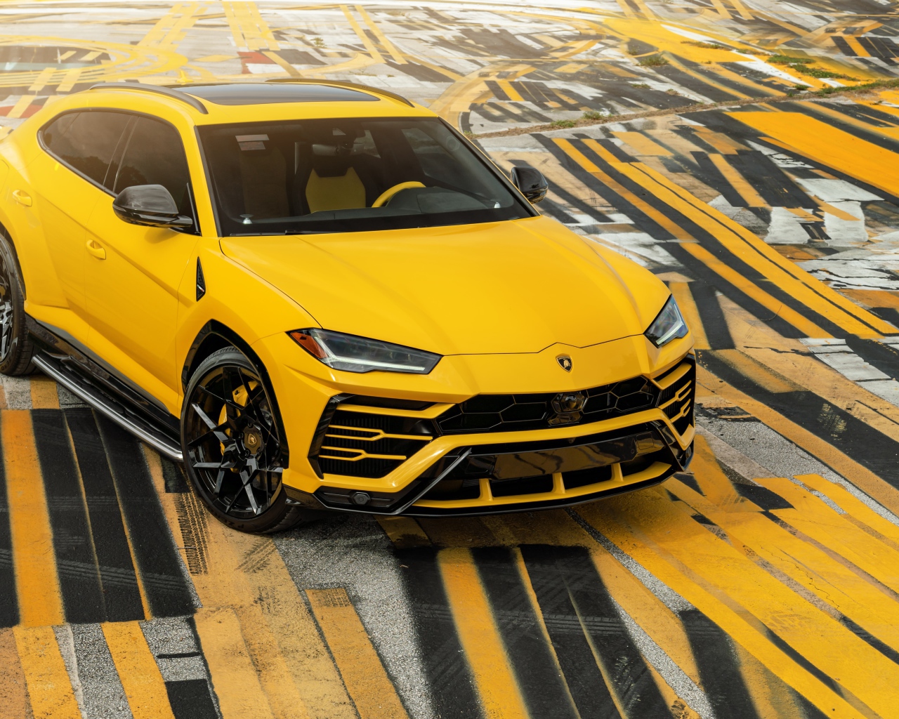 Yellow SUV Lamborghini Urus on multi-colored asphalt