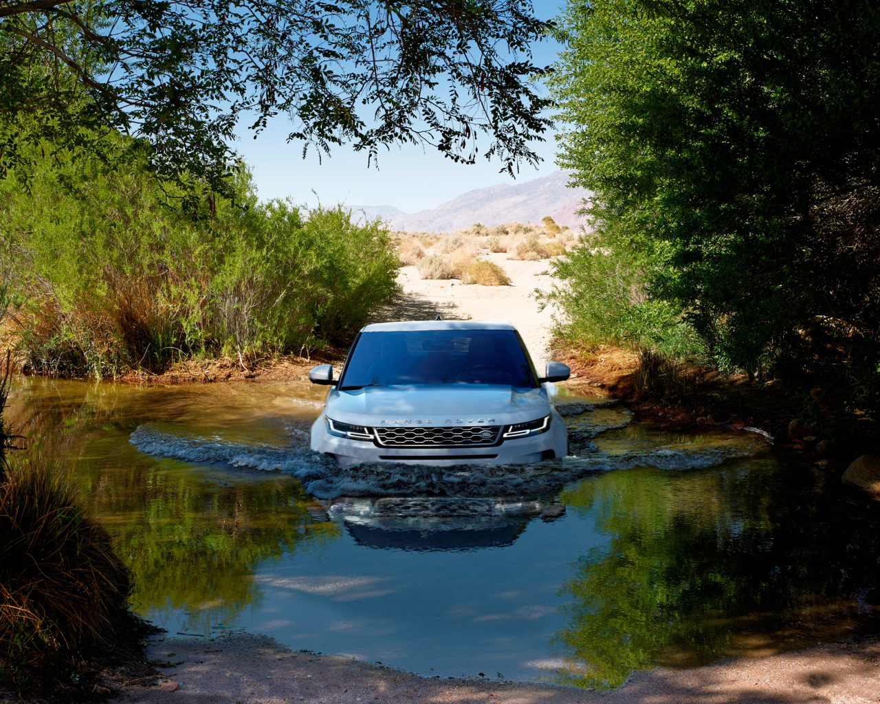 White SUV Range Rover Evoque rides on water
