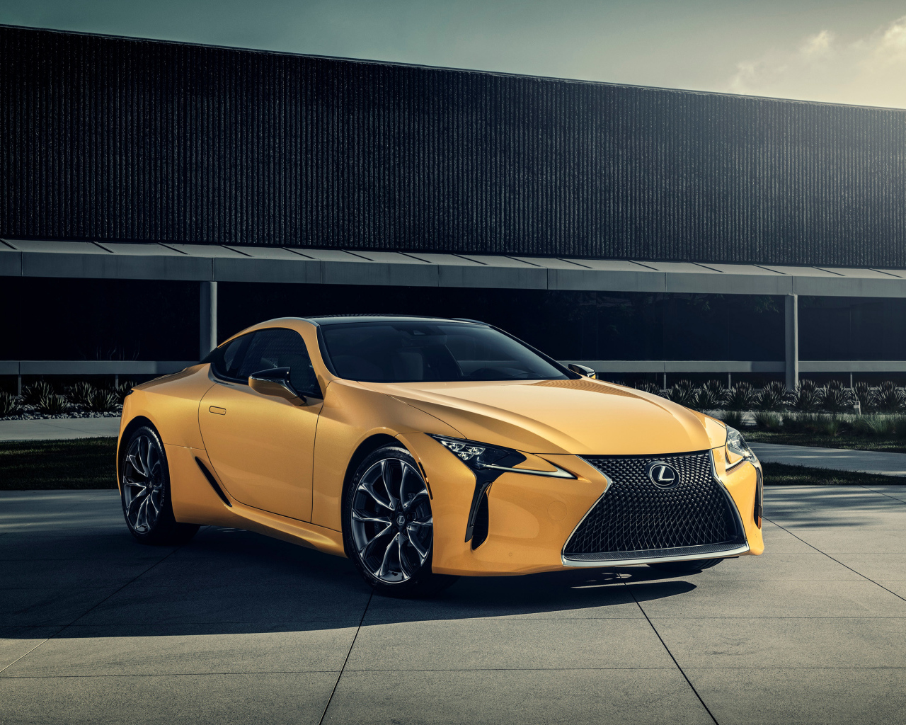 Желтый автомобиль Lexus LC 500 на фоне стены