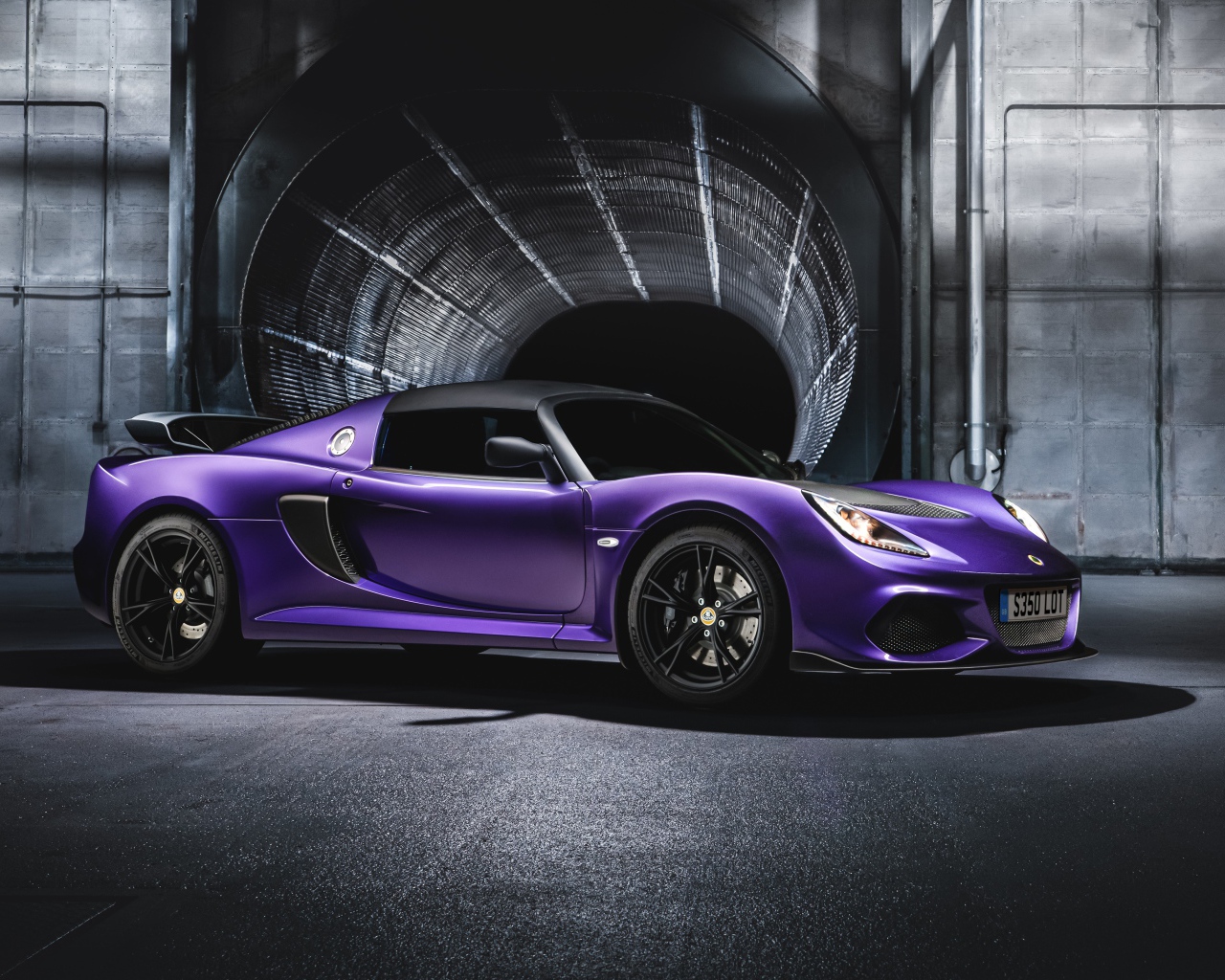 Сиреневый автомобиль Lotus Exige Sport 350 года у тоннеля 