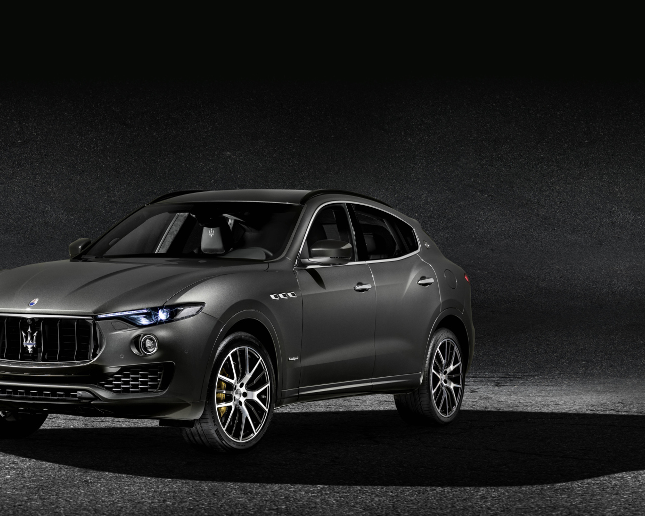Автомобиль Maserati Levante на сером фоне