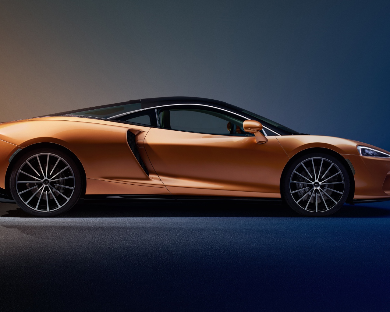 Оранжевый автомобиль McLaren GT Superlight 2019 года на синем фоне