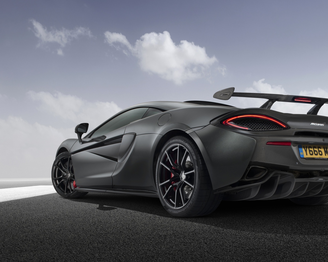 Серебристый автомобиль McLaren 720S вид сзади